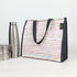 Striped lunch bag with black handles and trim,
