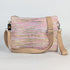 Multicolored striped handbag with beige strap on a light gray background